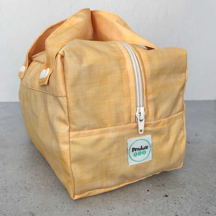 Detailed close up view of the durable woven bag securely zipped on a kitchen benchtop in lemon.