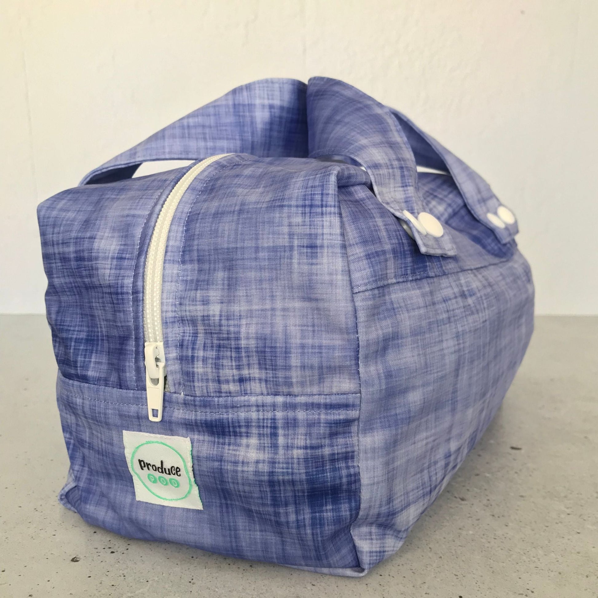 Detailed close up view of the durable woven bag securely zipped on a kitchen benchtop in plum.