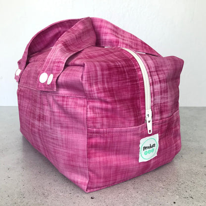 Detailed close up view of the durable woven bag securely zipped on a kitchen benchtop in rhubarb.