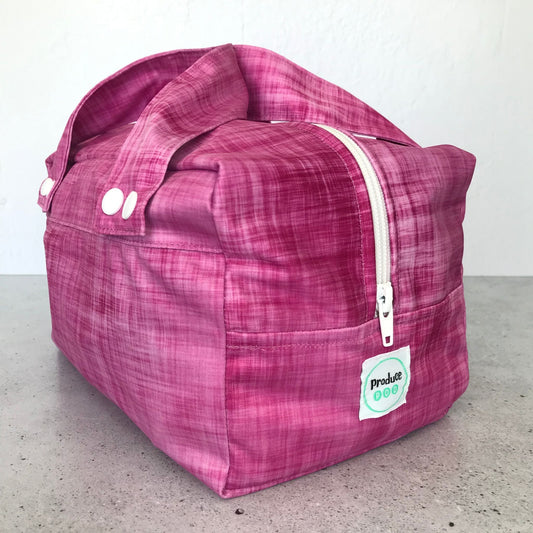 Detailed close up view of the durable woven bag securely zipped on a kitchen benchtop in rhubarb.