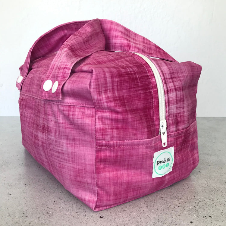 Detailed close up view of the durable woven bag securely zipped on a kitchen benchtop in rhubarb.