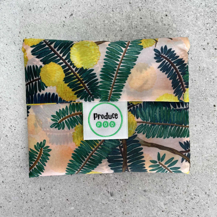 Close up view of the lightweight sixty gram reusable grocery bag folded entirely inside its own integrated self storing travel pouch for compact pocket storage. Wattle variant.