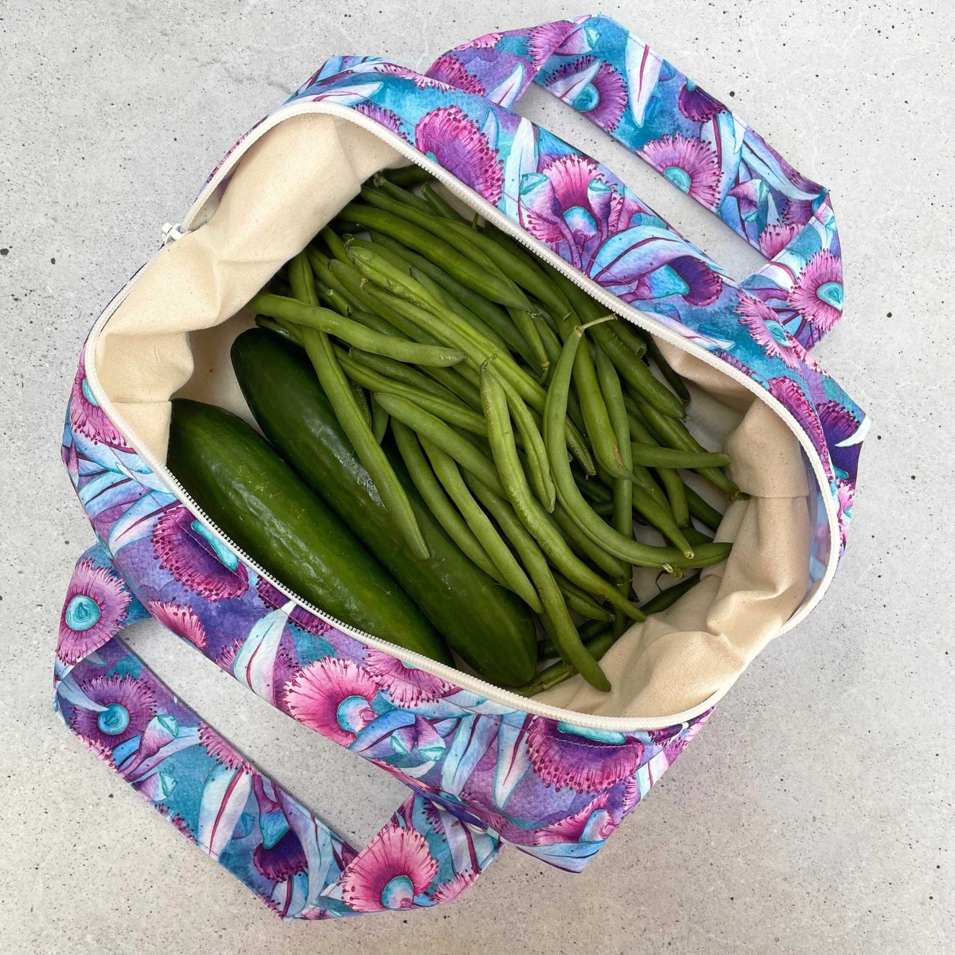 Single Produce Pod reusable veggie storage bag featuring a custom Gum blossom print standing open filled with fresh veg and fruit on a white background, available in Australia.