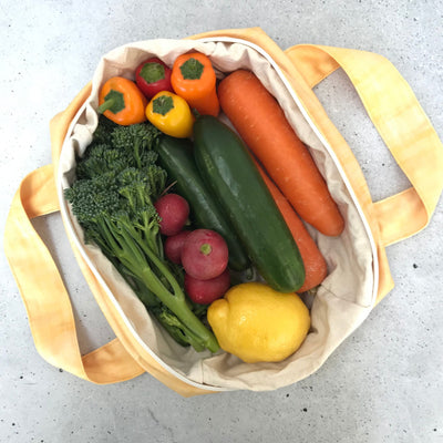 Single Produce Pod reusable veggie storage bag featuring a custom Lemon print standing open filled with fresh veg and fruit on a white background, available in Australia.
