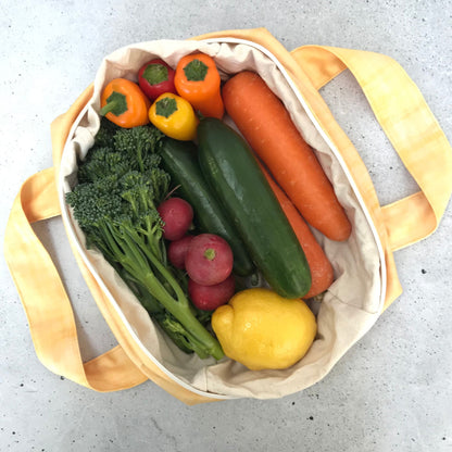 Single Produce Pod reusable veggie storage bag featuring a custom Lemon print standing open filled with fresh veg and fruit on a white background, available in Australia.