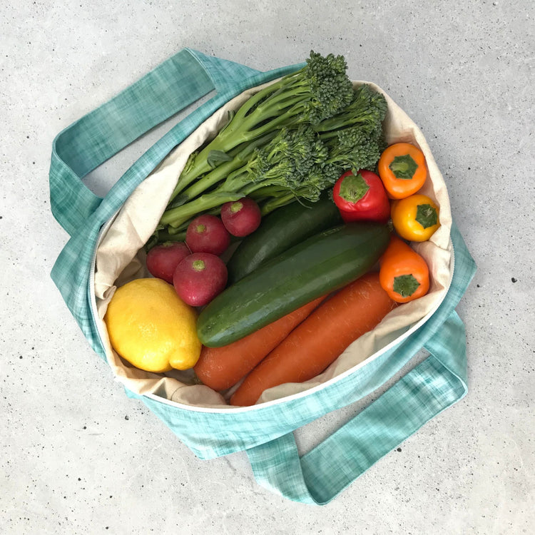 Single Produce Pod reusable veggie storage bag featuring a custom Ocean print standing open filled with fresh veg and fruit on a white background, available in Australia.