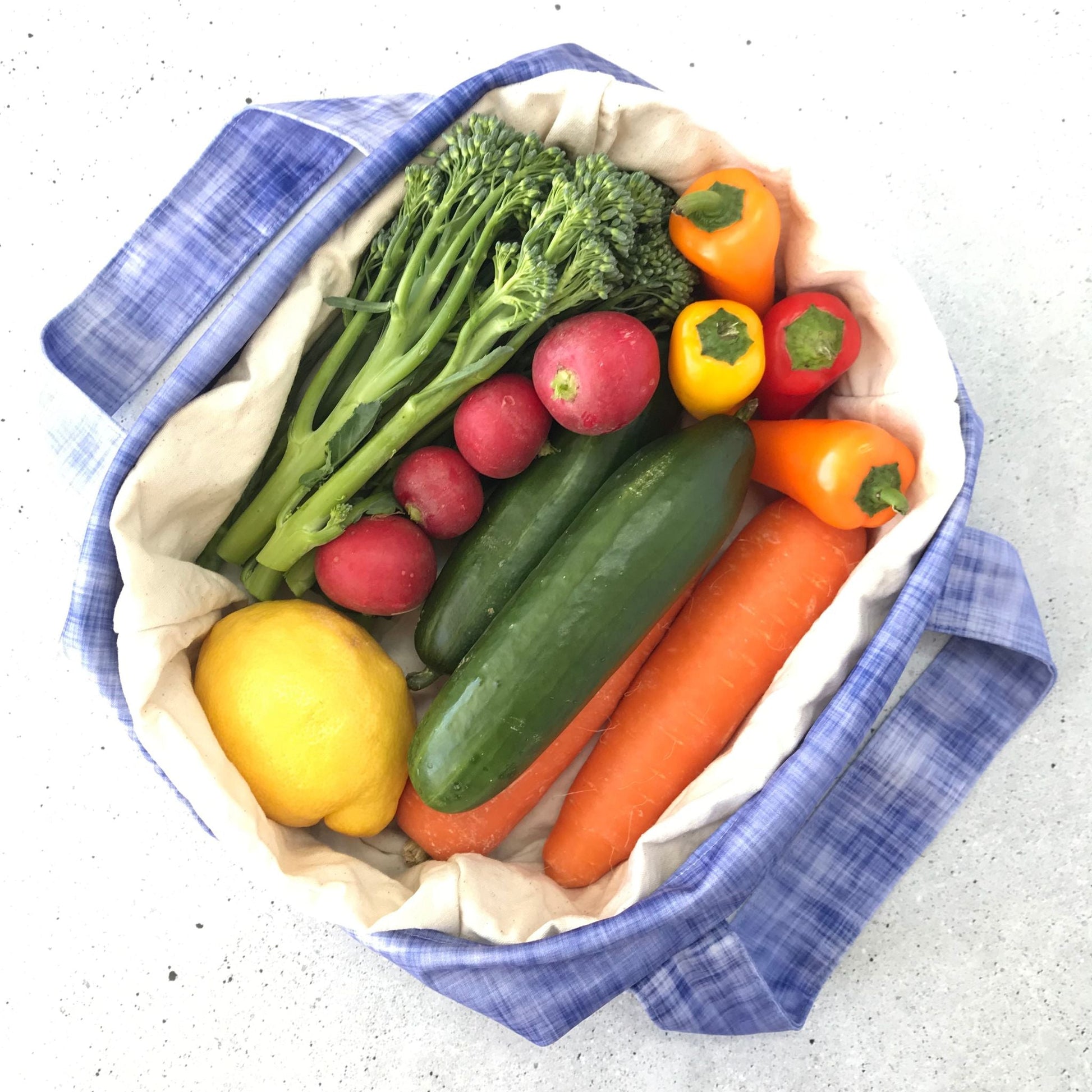 Single Produce Pod reusable veggie storage bag featuring a custom Plum print standing open filled with fresh veg and fruit on a white background, available in Australia.