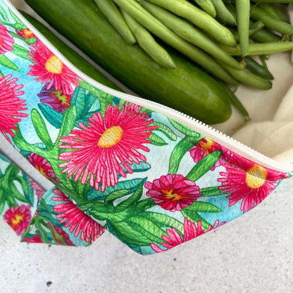 Single Produce Pod reusable veggie storage bag featuring a custom Sea fig print standing open filled with fresh veg and fruit closeup with beans on a stone background.