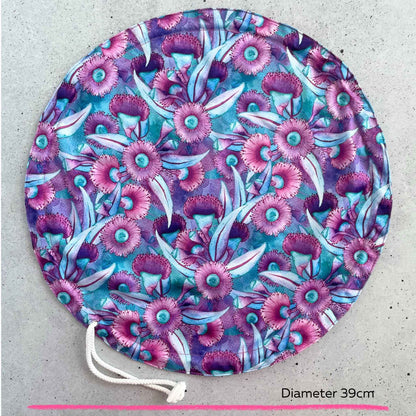 An extra large thirty nine centimeter Produce Pod reusable bowl cover in a Gum blossom print laid out on a surface top view.