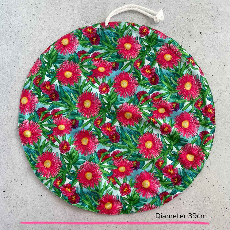 An extra large thirty nine centimeter Produce Pod reusable bowl cover in a Sea fig print laid out on a surface top view.