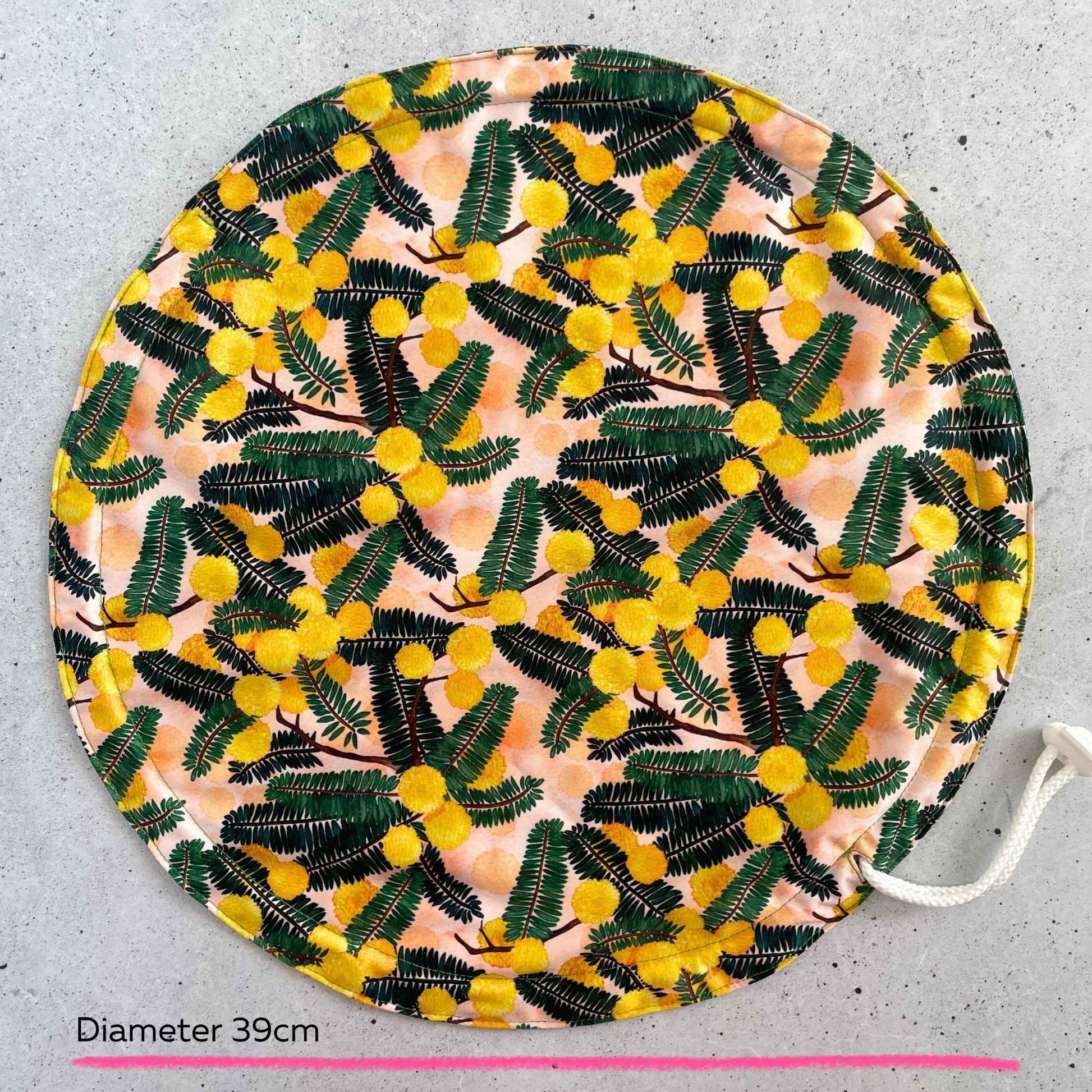 Produce Pod reusable bowl cover in a Wattle print laid out on a surface top view.