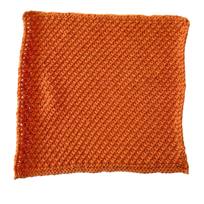 Pumpkin handmade knitted dishcloth made from absorbent recycled cotton for kitchen and bathroom use on a white background.