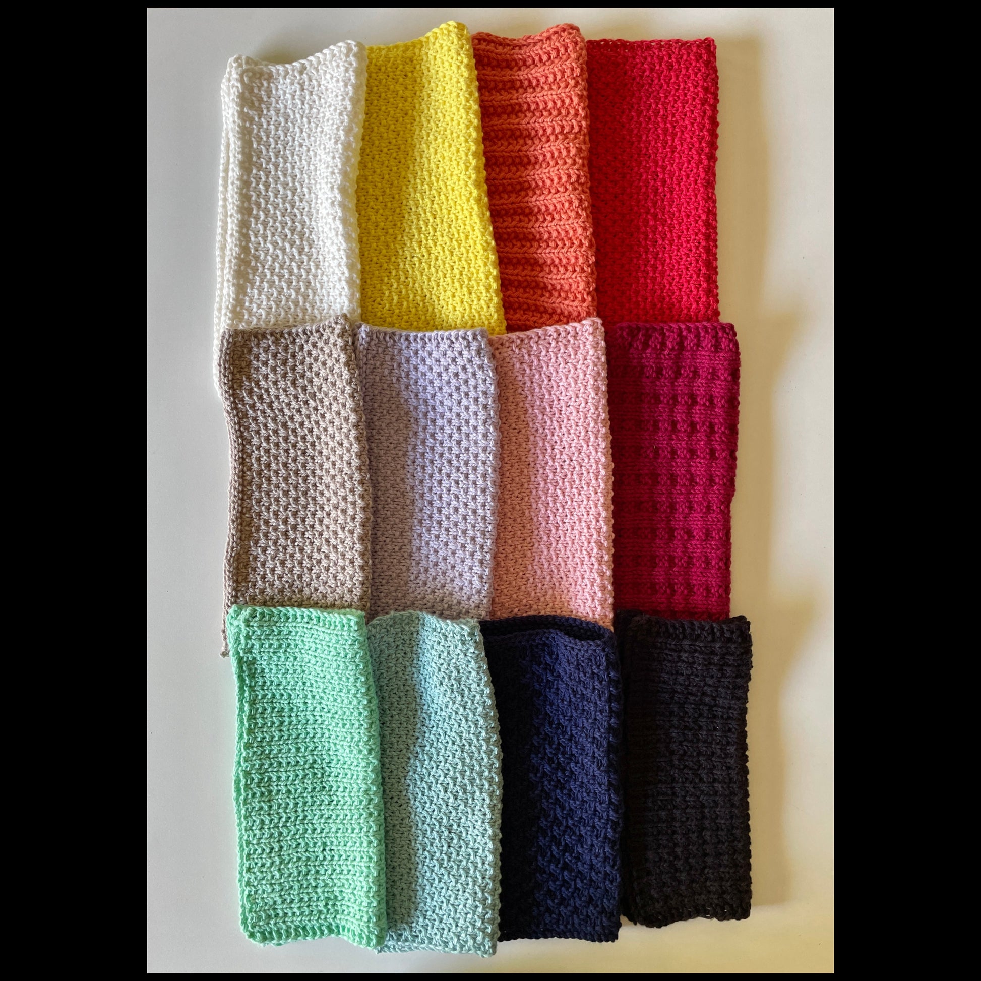 A neatly stacked pile of colorful handmade knitted cloths crafted from 100% recycled cotton for zero-waste home cleaning.