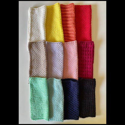 A neatly stacked pile of colorful handmade knitted cloths crafted from 100% recycled cotton for zero-waste home cleaning.