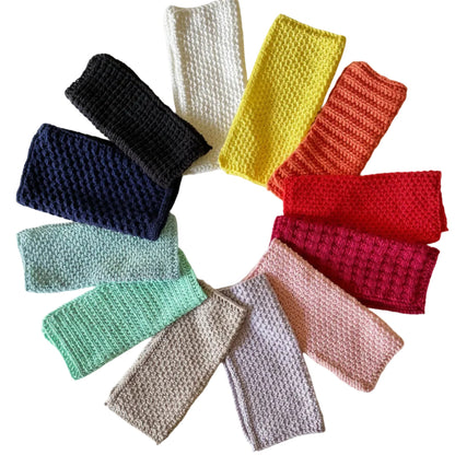 Colorful handmade knitted cloths crafted from 100% recycled cotton for zero-waste home cleaning on a white background.