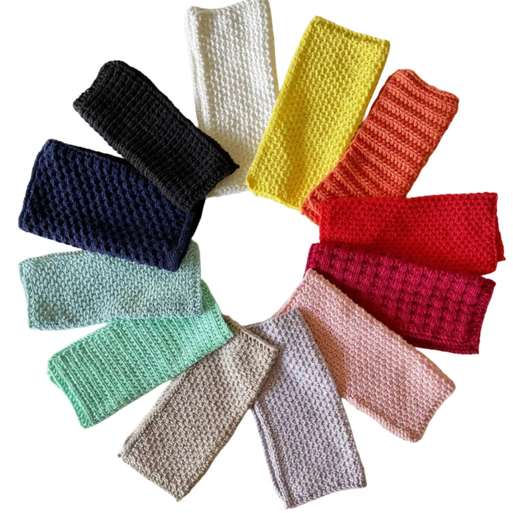 Colorful handmade knitted cloths crafted from 100% recycled cotton for zero-waste home cleaning on a white background.