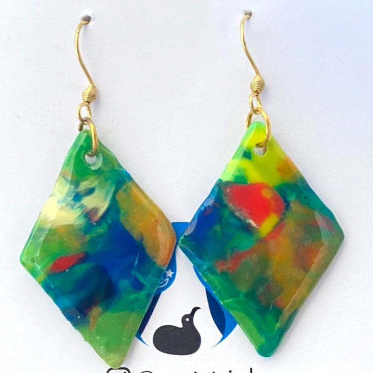A pair of handmade recycled plastic statement earrings in a geometric diamond dangle design featuring marbled green and blue tones, made in Australia.