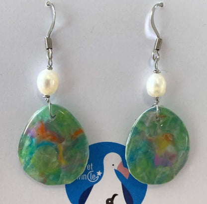 A pair of handmade recycled plastic drop dangle statement earrings in a marbled green nebula pattern, adorned with freshwater pearls.