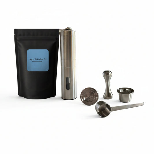 Pod Star barista pack for Espressotoria coffee machines featuring two stainless steel reusable pods, a manual coffee grinder, an espresso tamper, a scoop, and premium coffee beanson a white background.