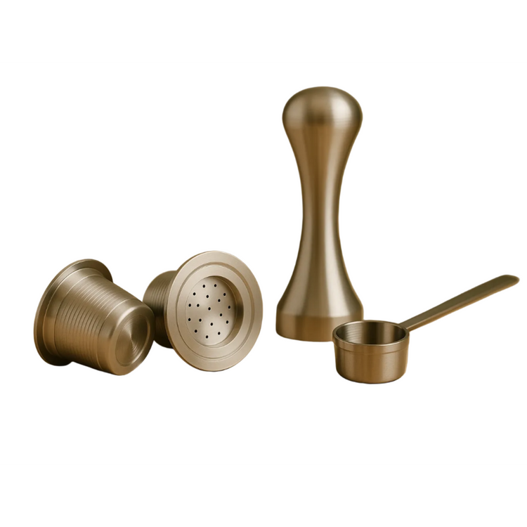 Two refillable stainless steel coffee pods displayed alongside a precision tamper and measuring scoop on a white background.