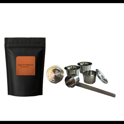 Pod Star family pack for Espressotoria coffee machines featuring four stainless steel reusable capsules, an espresso tamper, and a coffee measuring scoop on a white background.