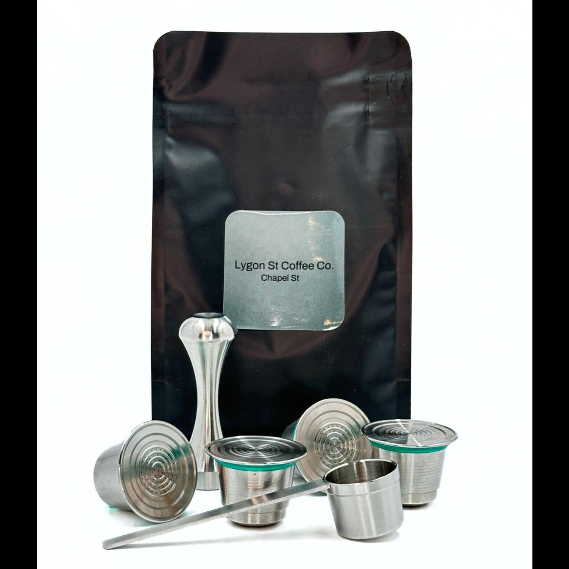 Pod Star family pack for Nespresso Original line coffee machines featuring four stainless steel reusable capsules, an espresso tamper, and a coffee measuring scoop on a white background.