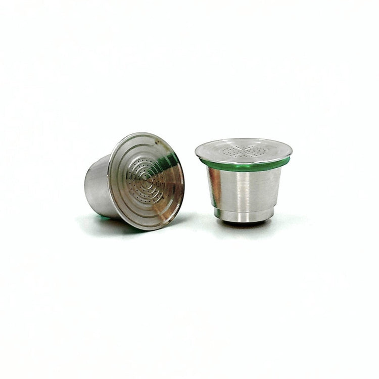 Two refillable stainless steel coffee pods on a white background.