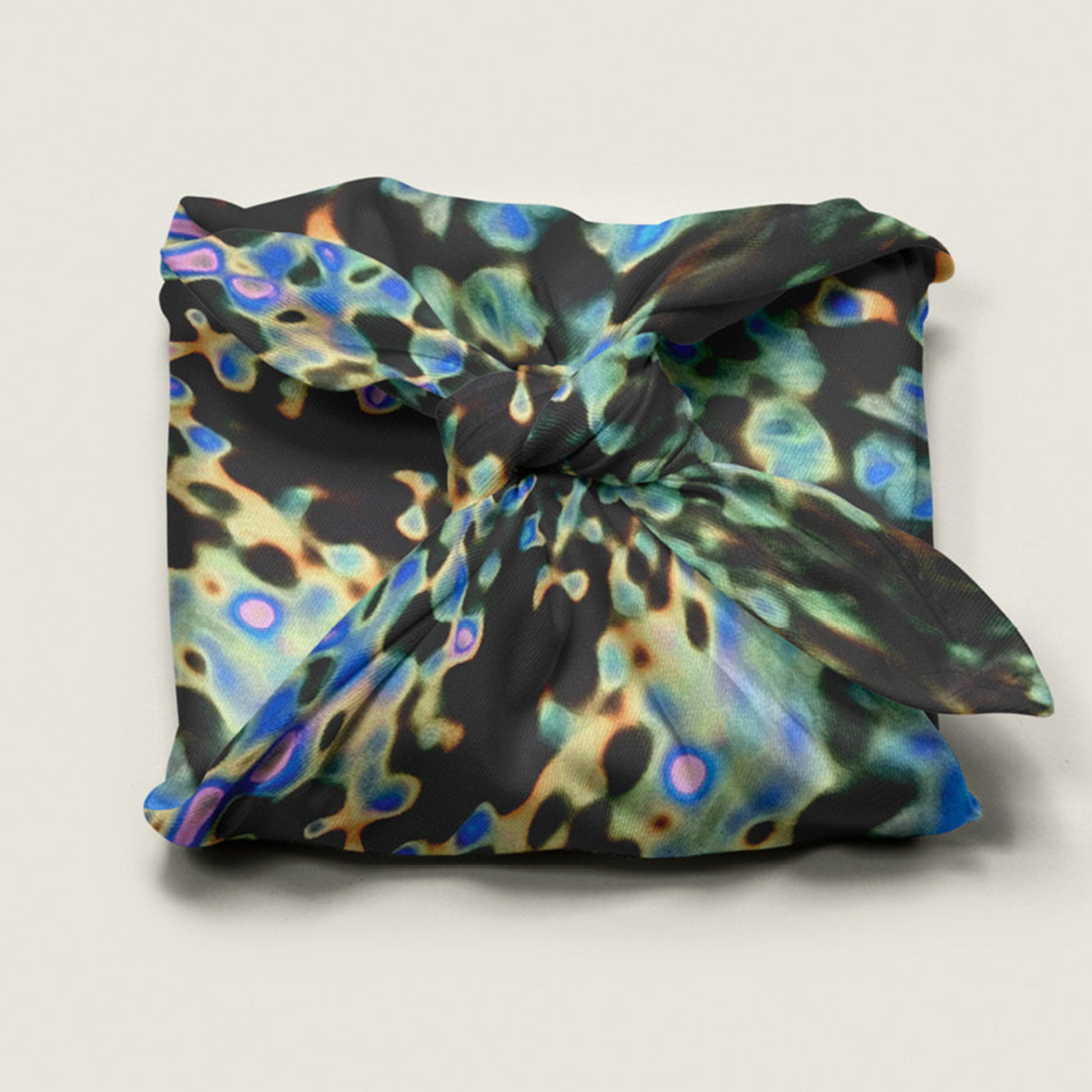 Reusable fabric gift wrap by Wrap Revolution in the abstract digital puddle pattern, wrapped around a gift box, eco friendly furoshiki design in Australia.