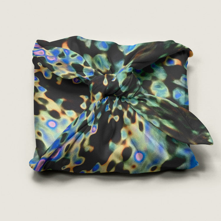 Reusable fabric gift wrap by Wrap Revolution in the abstract digital puddle pattern, wrapped around a gift box, eco friendly furoshiki design in Australia.