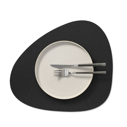 Curve recycled leather placemat styled with a plate, knife and fork.