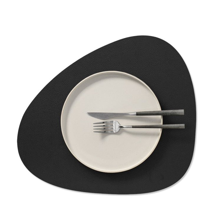 Curve recycled leather placemat styled with a plate, knife and fork.