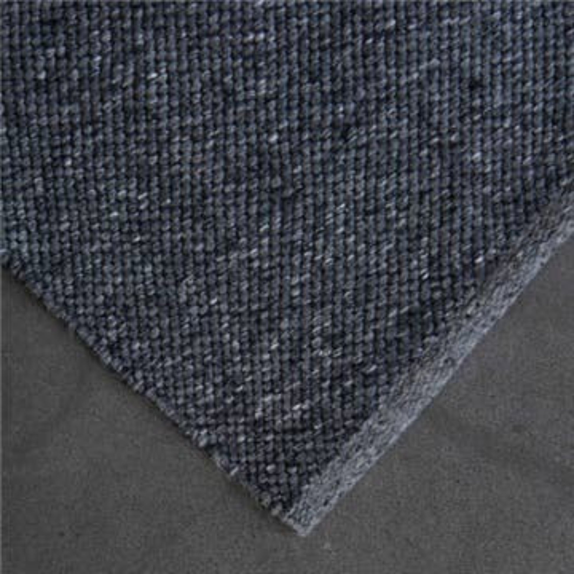 High-resolution close-up corner view showing the flatweave texture of the Zebra Home Clements eco-friendly charcoal grey floor rug.