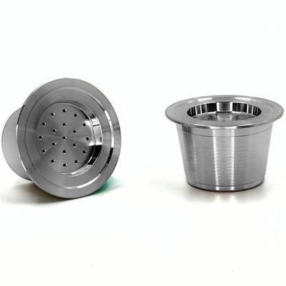 Close-up view of two eco-friendly refillable capsules for Aldi K-fee, Caffitaly or Verismo machines on a white background.