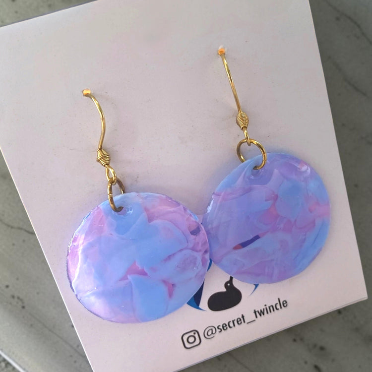 Studio flat lay presentation of the clear purple circular geometric upcycled earrings, offering an ideal sustainable fashion gift choice.