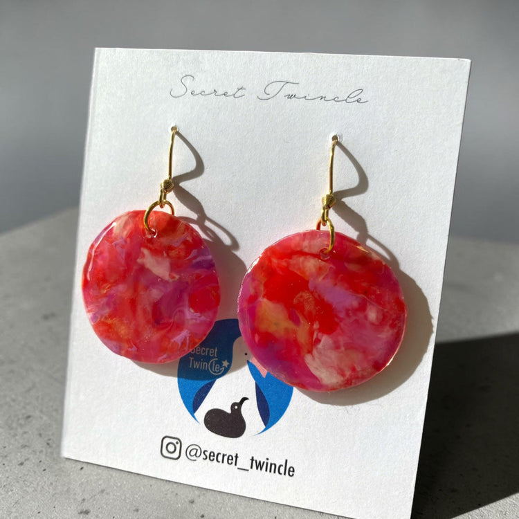 Studio flat lay presentation of the pink and red circular geometric upcycled earrings, offering an ideal sustainable fashion gift choice.