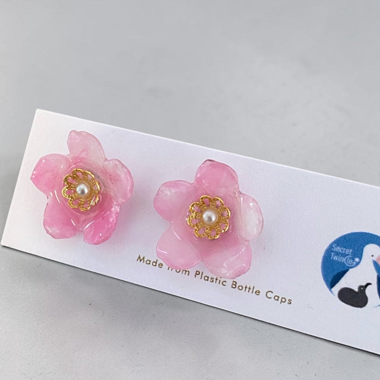 Studio flat lay presentation of the pink cherry blossom Sakura recycled plastic earrings, showing a beautiful eco-friendly jewelry gift.
