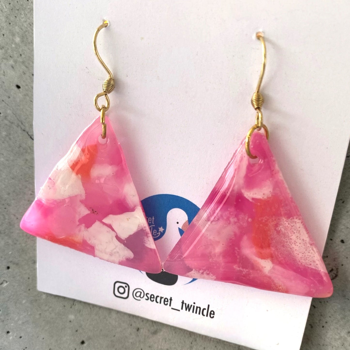 Flat lay presentation of the geometric pink and white triangle-shaped upcycled dangles, offering a perfect sustainable jewelry gift option.