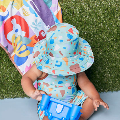 Toddler modeling the Tyoub ocean glass and brown junior sun hat with matching bather for sun smart safety in Australia.