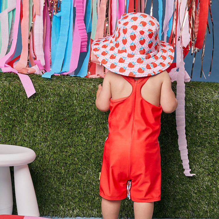 Young child wearing the Tyoub strawberry red junior sun hat in a studio setting back view.