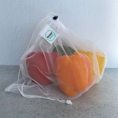 See through recycled mesh grocery bag holding capsicum for quick scanning at the supermarket checkout.