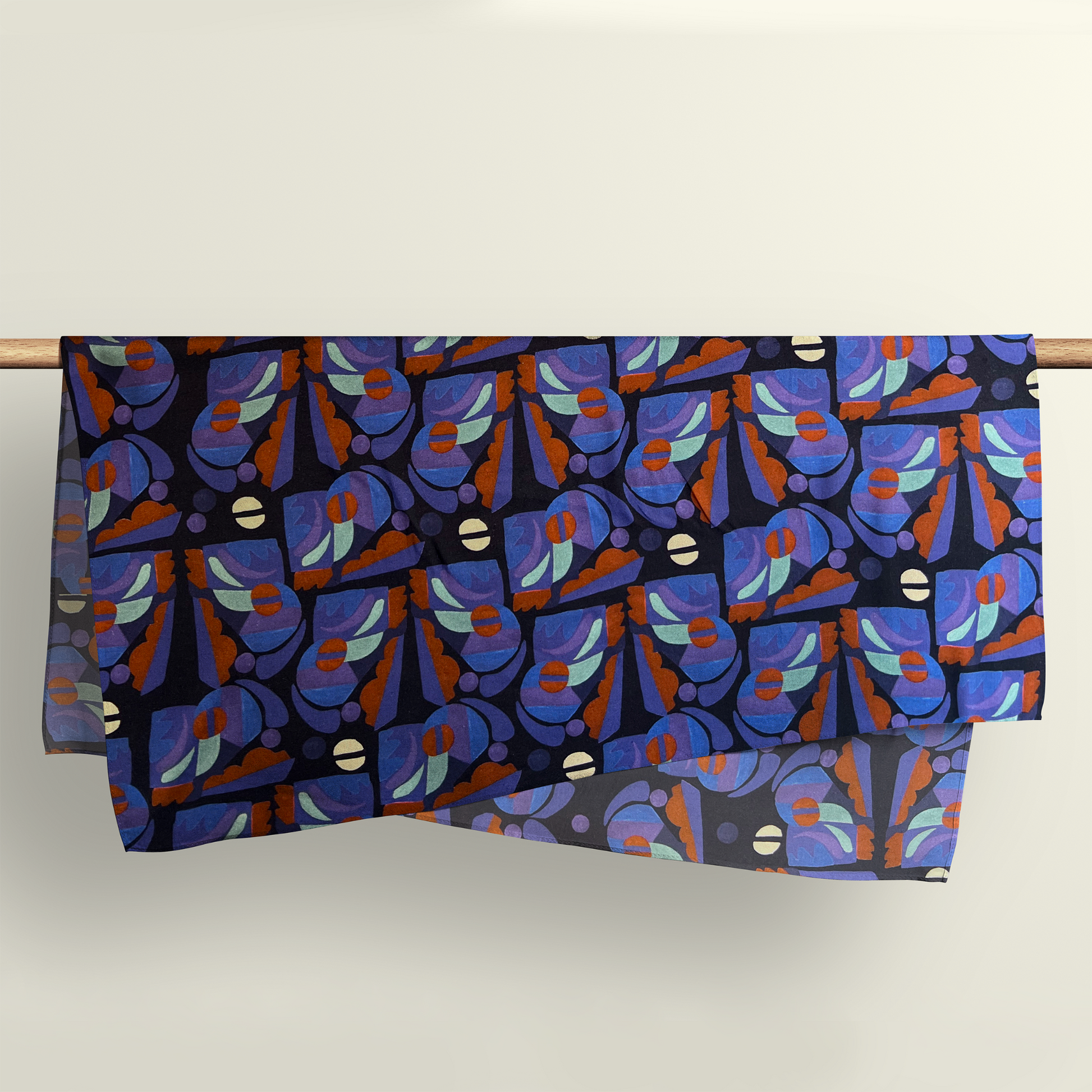 The Tribal Beats pattern fabric wrap draped over a wooden rod to show the premium deadstock material texture.
