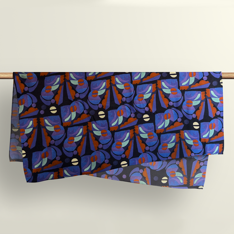 The Tribal Beats pattern fabric wrap draped over a wooden rod to show the premium deadstock material texture.