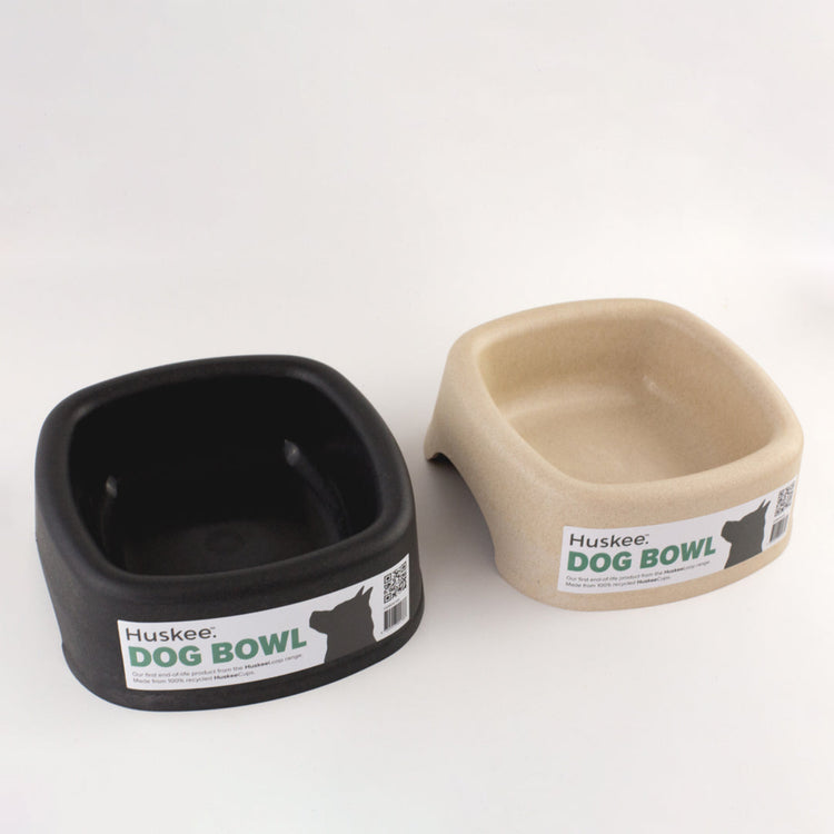 Two Huskee Eco-firendly recycled coffee cup Dog Bowls, one charcoal and one natural, on a white background.