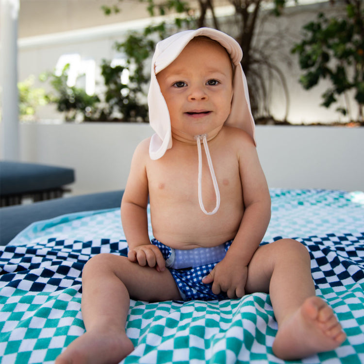Baby wearing a cream Tyoub legionnaires sun hat for Sun Smart UV coverage outdoors in Australia.