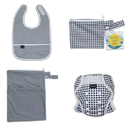 Three-piece baby swim gift set featuring an adjustable nappy, wet bag, and waterproof bib in black check.