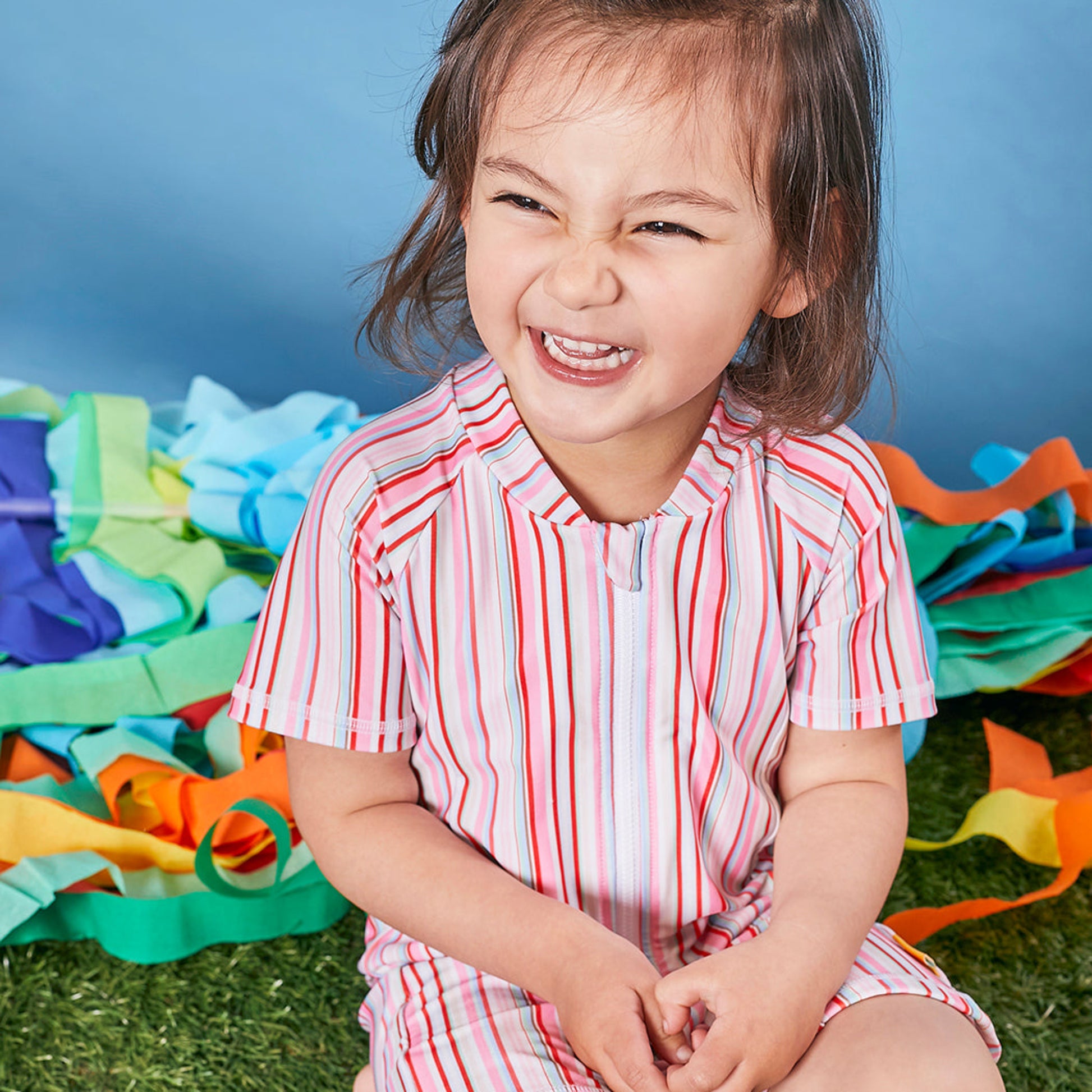 Close up detail of the long front zipper guard on a Tyoub kids uv protective sunsuit for easy dressing.
