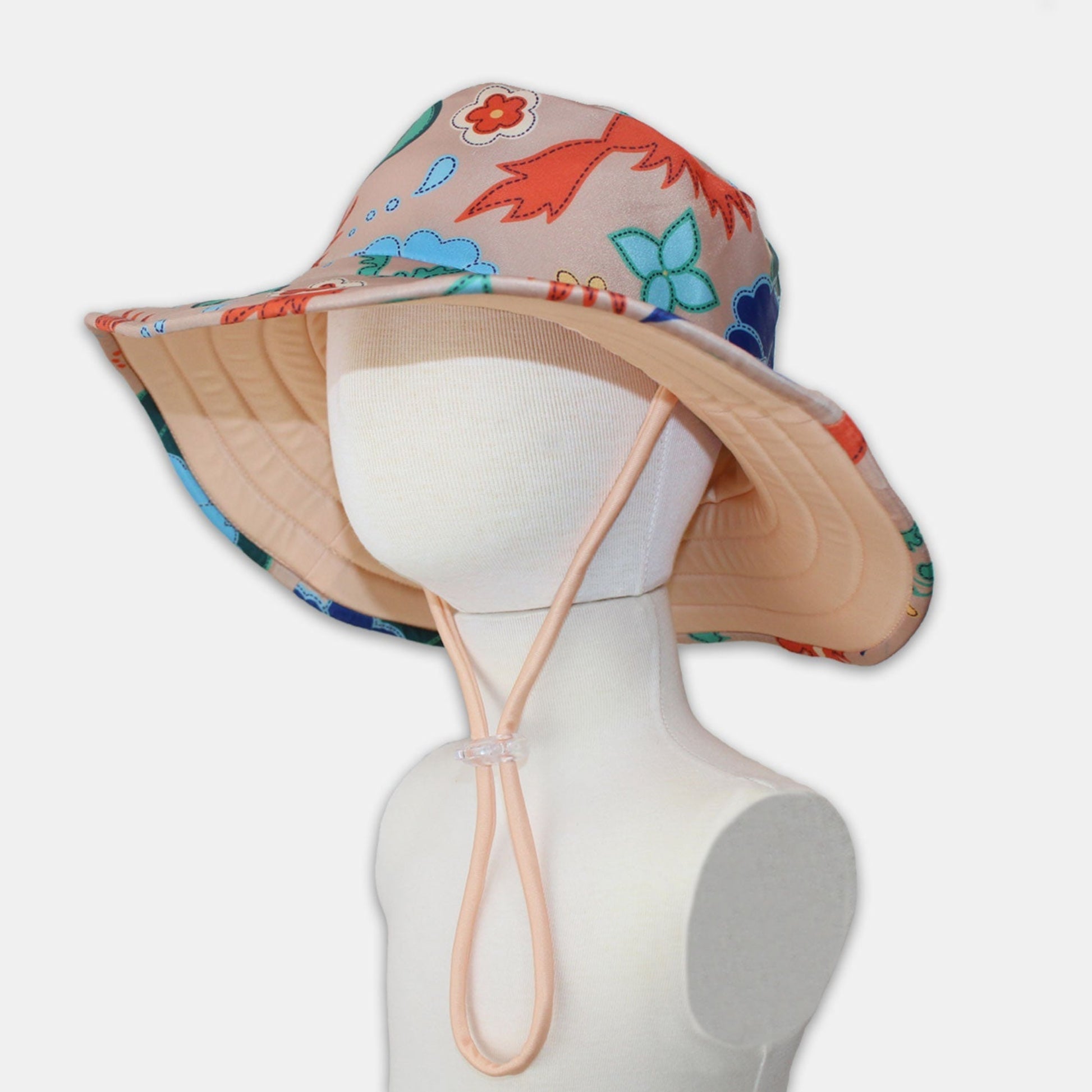 Kids wide brim swim hat in a vanilla cream phoenix floral pattern featuring an adjustable toggle chin strap.