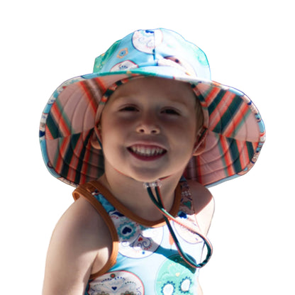 Kids wide brim swim hat in an aqua blue sugar skull print with a colorful striped serape pattern under the brim.
