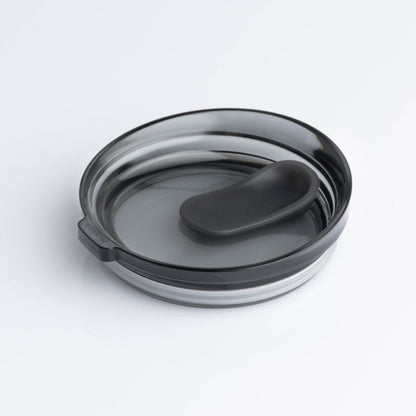 A universal HuskeeRenew translucent reusable coffee cup lid in smoke made from high-performance recycled polymer.