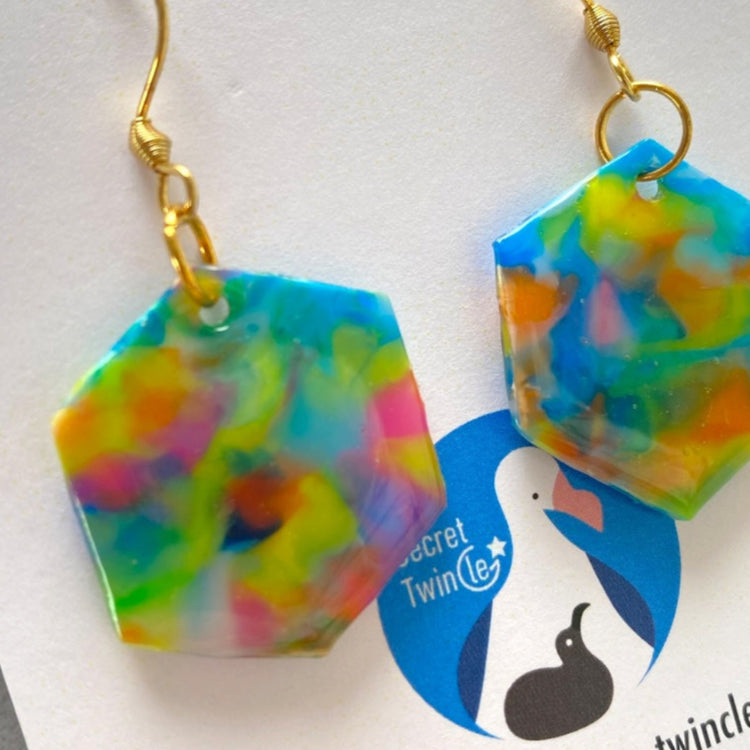 Detailed close-up highlighting the unique marbled surface finish and artisan blue color blend of the recycled plastic hexagon earrings.
